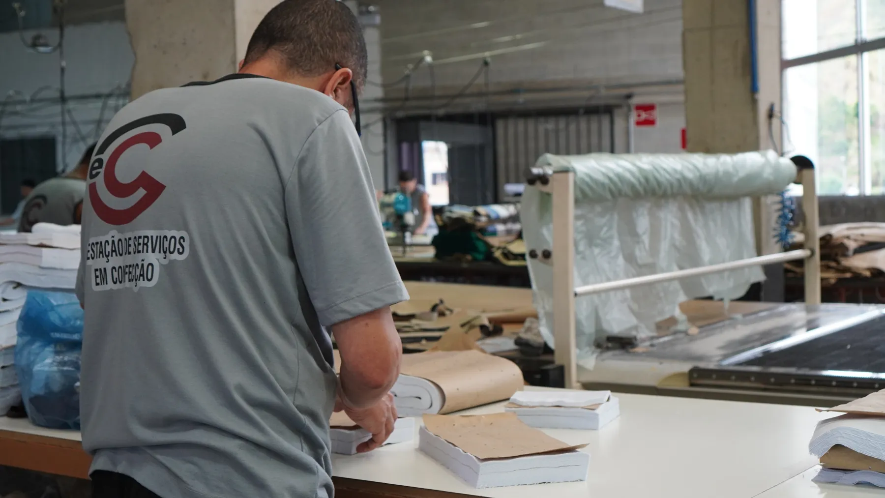 Colaborador da C&C organizando peças cortadas na mesa de corte
